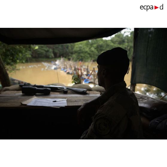 Un marsouin du 9e régiment d'infanterie de marine (9e RIMa) surveille les allées et venues depuis sa guérite au barrage Papa Constant à Maripasoula, en Guyane française.