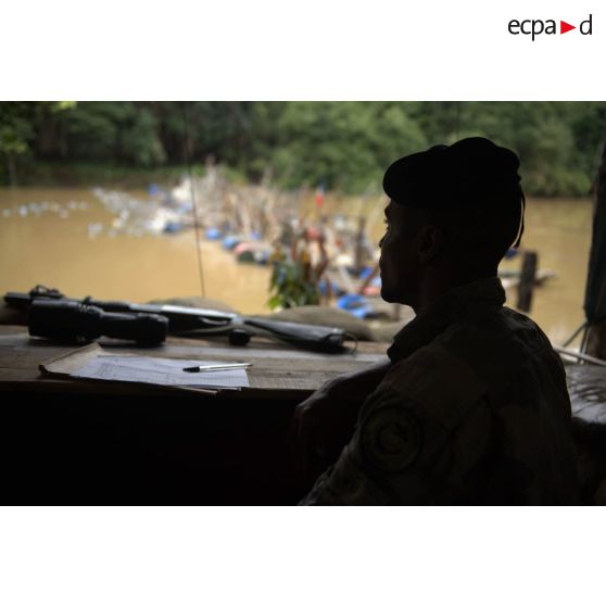 Un marsouin du 9e régiment d'infanterie de marine (9e RIMa) surveille les allées et venues depuis sa guérite au barrage Papa Constant à Maripasoula, en Guyane française.