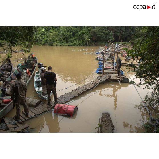 Un gendarme contrôle un piroguier aux côtés d'un marsouin du 9e régiment d'infanterie de marine (9e RIMa) au barrage Papa Constant à Maripasoula, en Guyane française.
