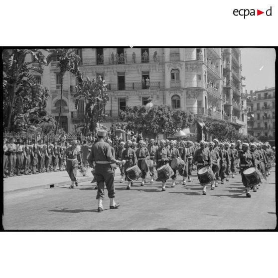 Le 7e régiment de tirailleurs algériens (RTA) et sa musique défilent dans les rues d'Alger.