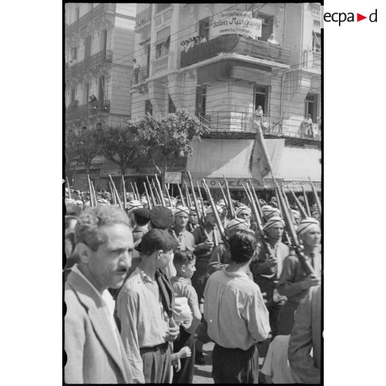Défilé du 7e régiment de tirailleurs algériens (RTA) dans les rues d'Alger, au milieu de la foule.