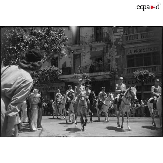 Le général de brigade Jean Breuillac, commandant la division territoriale d'Alger et l'escorte précédant le 1er régiment de tirailleurs africains (RTA), défilent à cheval, dans les rues d'Alger.