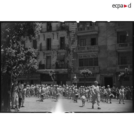 Le 1e régiment de tirailleurs algériens (RTA) défile en ville avec sa mascotte.