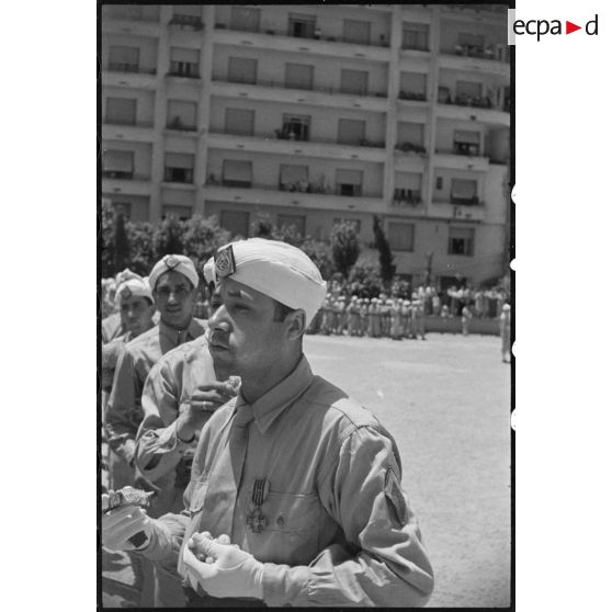 Portrait d'un militaire du 1er régiment de tirailleurs algériens (RTA) qui se restaure, sur l'esplanade du gouvernement général de l'Algérie.