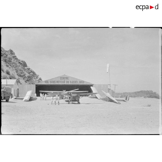Vue d'un hangar du centre de vol sans moteur du Djebel Diss, devant lequel sont garés les planeurs de l'école.