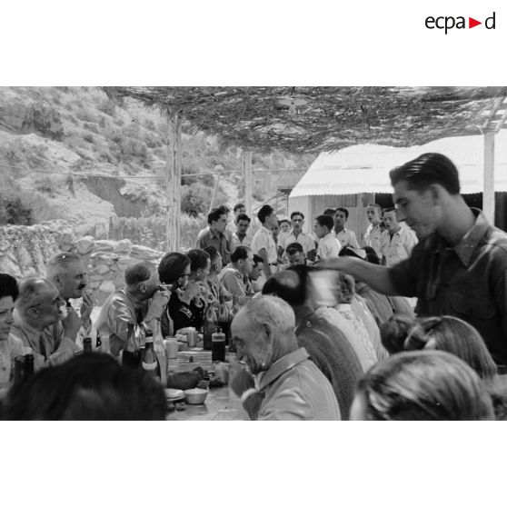 Le général de corps d'armée Henry Martin est attablé avec des personnalités civiles, militaires et des élèves de l'école de vol à voile de Djebel Diss.