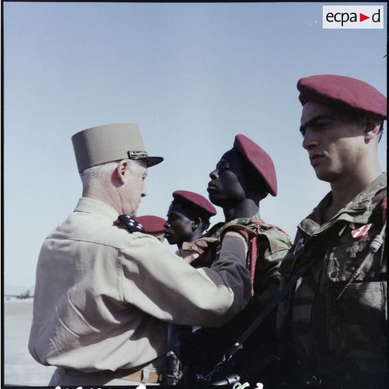 Le général Raoul Salan, commandant supérieur interarmées et commandant la Xe Région Militaire, décore de la Croix de la valeur militaire des engagés africains appartenant au 8e Régiment de parachutistes coloniaux (RPC).