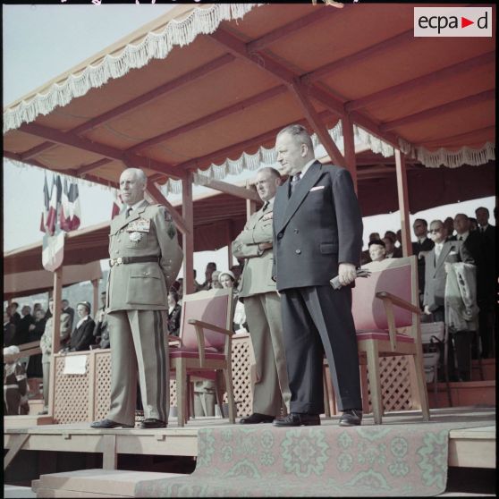 Les généraux Jacques Allard et Raoul Salan avec le ministre Robert Lacoste, lors d'une cérémonie militaire dans un stade.