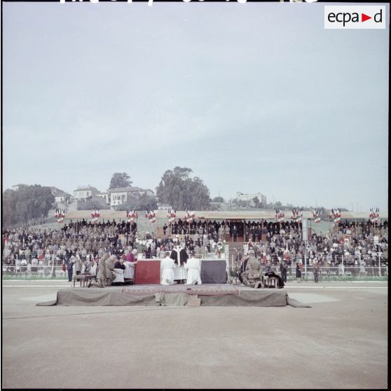 Cérémonie militaire et religieuse dans un stade.