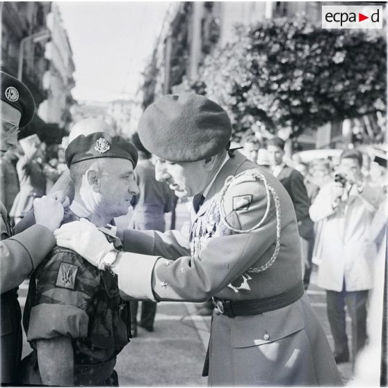[Le général de division Jacques Massu remet la Légion d'honneur à un chef de bataillon (troupes de Marine) de la 10e division parachutiste en Algérie, 1960.]