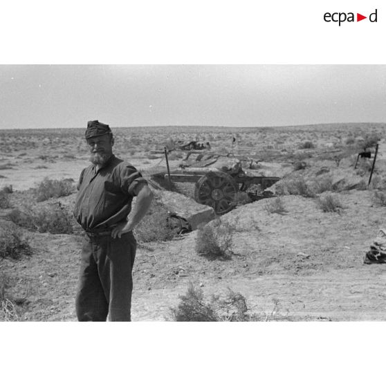 Un soldat italien pose devant une alvéole qui contient un canon de 75/27 M11.