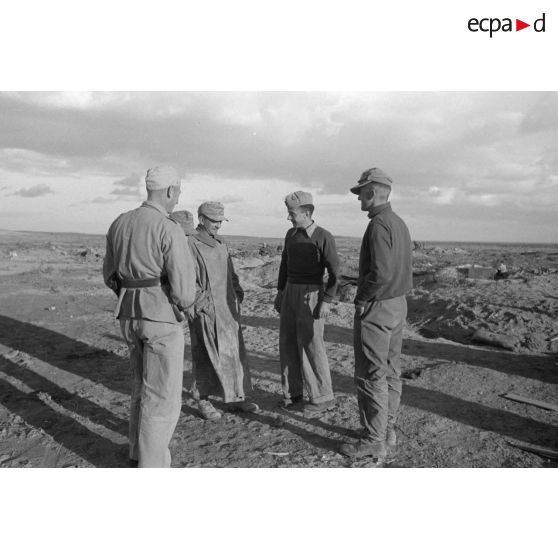 Un groupe d'officiers germano-italiens discutte, au premier plan, à gauche, le caméraman Hermann Dressler.