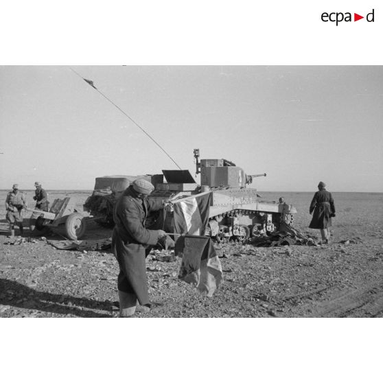 Un char léger M3 Stuart détruit, il appartiendrait aux "rats du désert" (desert rats) comme l'atteste l'insigne sur l'avant droit du blindé.