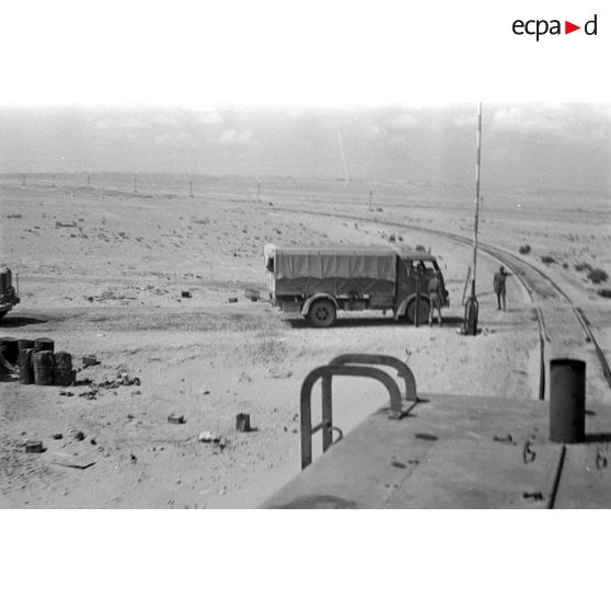 A bord d'une locomotive Henschel diesel, la voie ferrée croise une route.