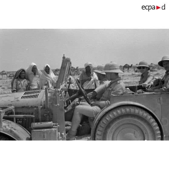 A bord d'une Horch Kfz.15, des reporters rencontrent des bédouins.