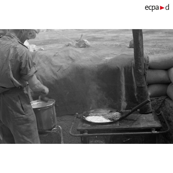 Une cuisinière en fonte réchauffe le repas d'un sous-officier.