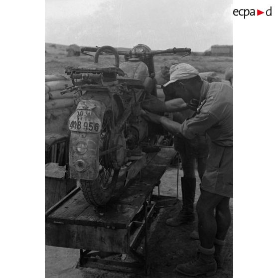 En Afrique, au sein d'une unité de maintenance (Werkstatt Kompanie), la maintenance de motocyclettes BMW qui semblent déjà bien éprouvées par le désert et les conditions climatiques.