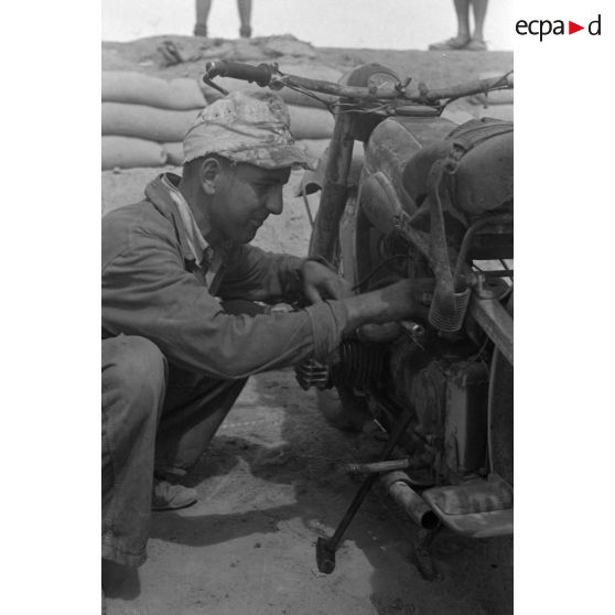 En Afrique, au sein d'une unité de maintenance (Werkstatt Kompanie), la maintenance de motocyclettes BMW qui semblent déjà bien éprouvées par le désert et les conditions climatiques.