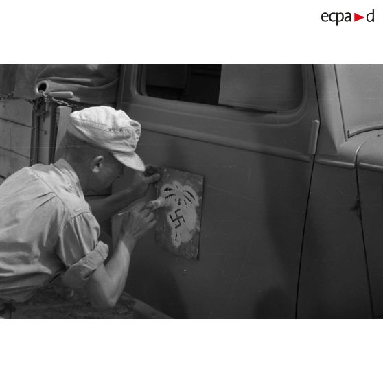 Application de l'insigne de l'Afrika-Korps à l'aide d'un pochoir.