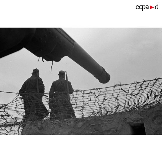En Tunisie, des sentinelles allemandes surveillent un canon français.