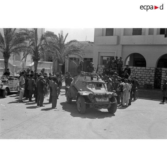 A Benghazi, un blindé SdKfz-222 et une voiture Kübelwagen au milieu de civils italiens.