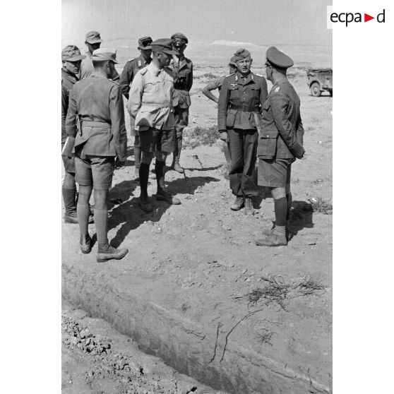 Un groupe d'officiers et les généraux Gause et Rommel écoutent le rapport d'un lieutnant (Leutnant).