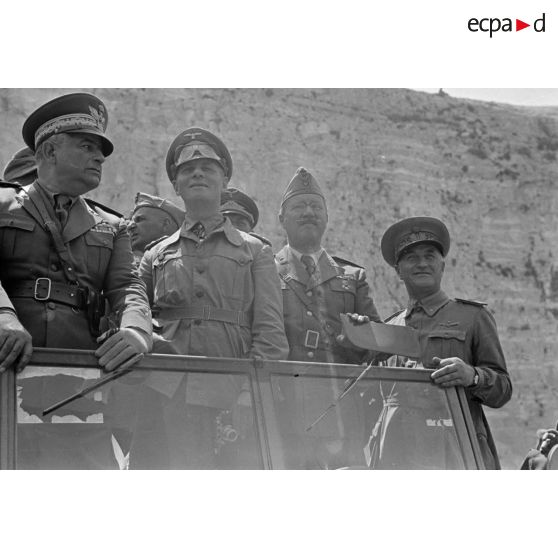 Debout dans une voiture, les généraux Rommel et Gambara, accompagnés d'autres officiers italiens et allemands, assistent à une course de chevaux.