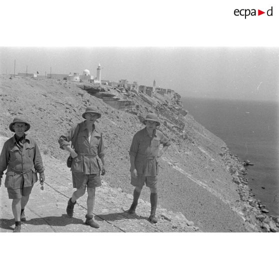 Trois artistes se promènent sur les falaises de la côte.
