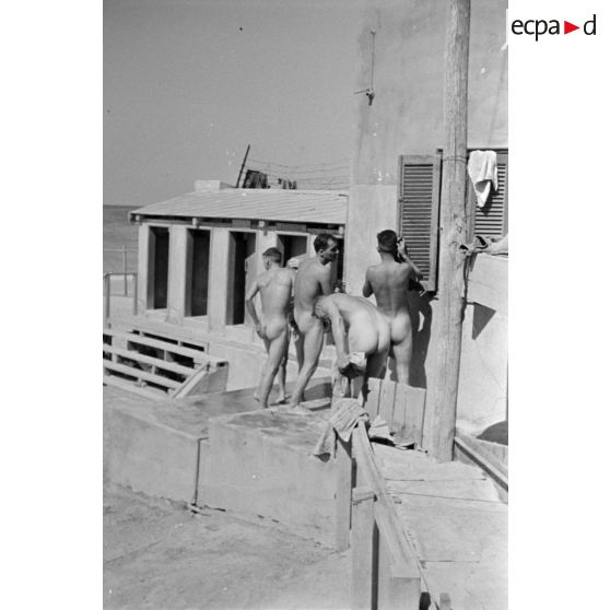 Des prisonniers nus vont ou reviennent de la douche.