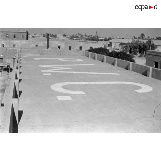 Inscription PWC (prisonners of war camps ou camp de prisonniers) sur un toit, destinée à éviter le bombardement du camps par les Britanniques.