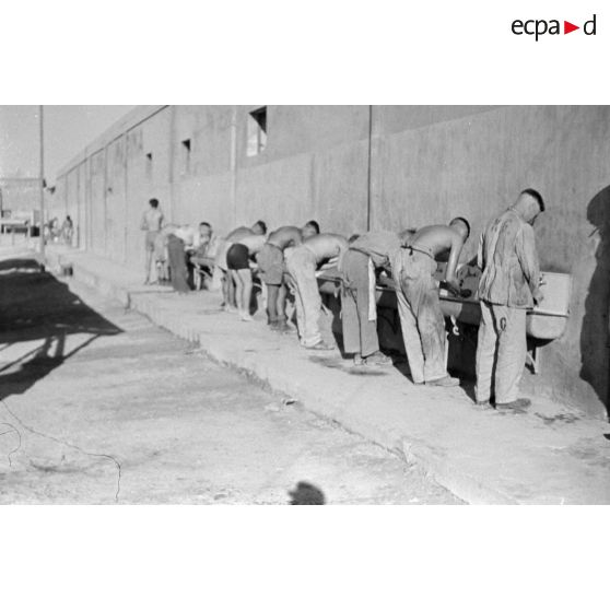 Des prisonniers britanniques lavent leurs effets, dans le dos de certains on note les lettres KG pour Kriegsgefangener (prisonnier de guerre).