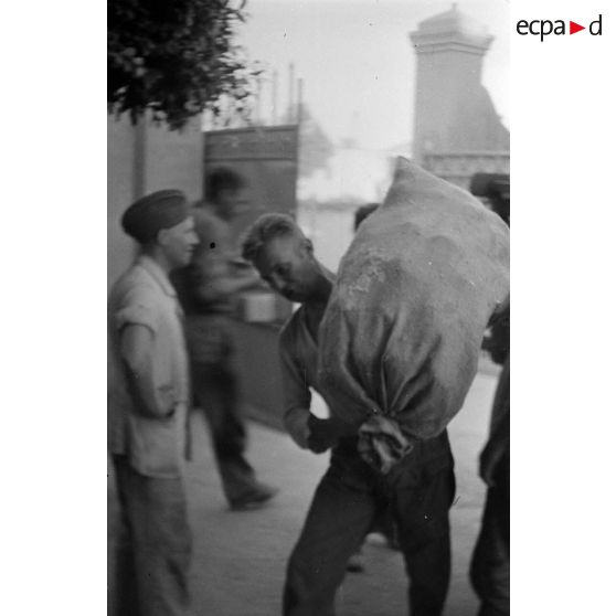 Les prisonniers britanniques déchargent une charrette.