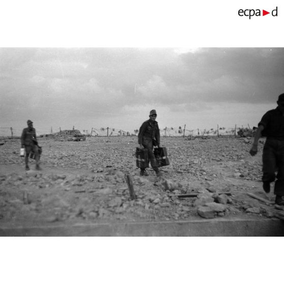 Des soldats amènent des bidons d'eau (jerrycans).