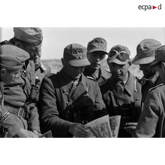 L'Oberst Cramer regarde des journaux allemands en compagnie de ses officiers.