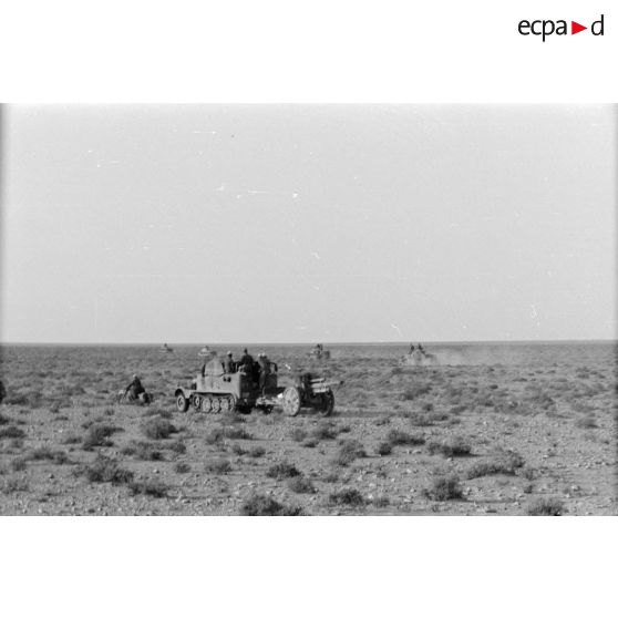 Un semi-chenillé sd.kfz.11 tracte un canon 10,5 cm lFH-18 du I-Art.Rgt-33 en compagnie de Panzer III (Pz-III) du Panzer Regiment 8 (Pz.Rgt-8).