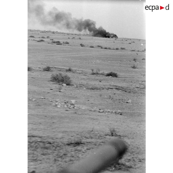 Un camion britannique en flamme dans le désert.