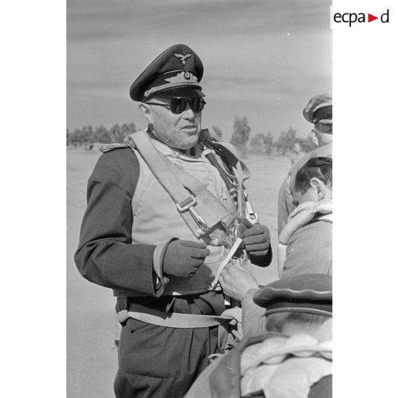 Le maréchal (Generalfeldmarschall) Kesselring, entouré d'officiers de la Luftwaffe et de la Kriegsmarine, est équipé d'un parachute.