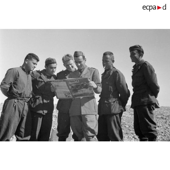 Un officier et des soldats italiens lisent le journal italien Fronte.