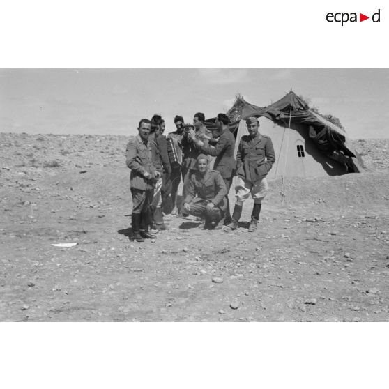 Un groupe d'officiers et de soldats italiens, dont un accordéoniste, pose devant une tente.