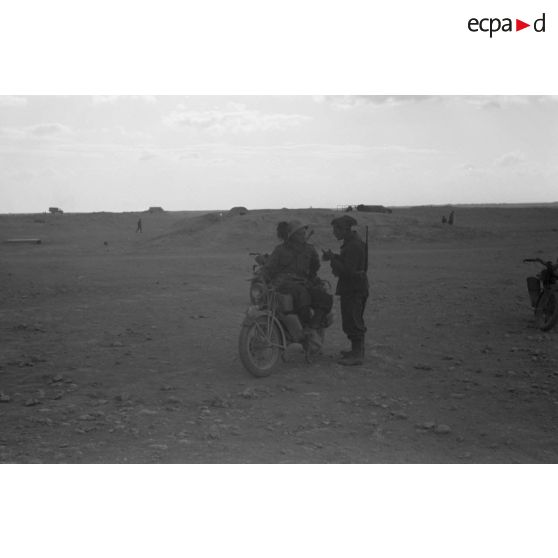 Un fantassin italien discute avec un Bersaglier assis sur sa moto.