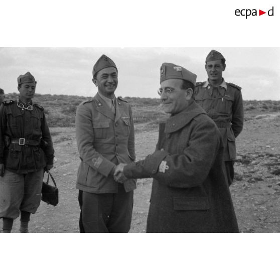 Un général de division italien est reçu par des officiers et des soldats.