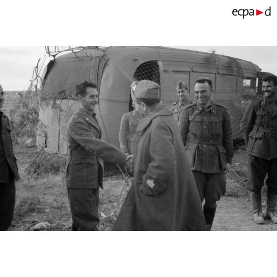 Un général de division italien est reçu par des officiers et des soldats.