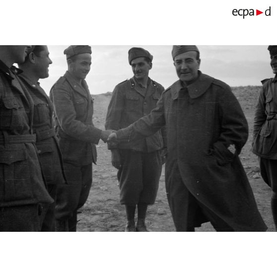 Un général de division italien est reçu par des officiers et des soldats.