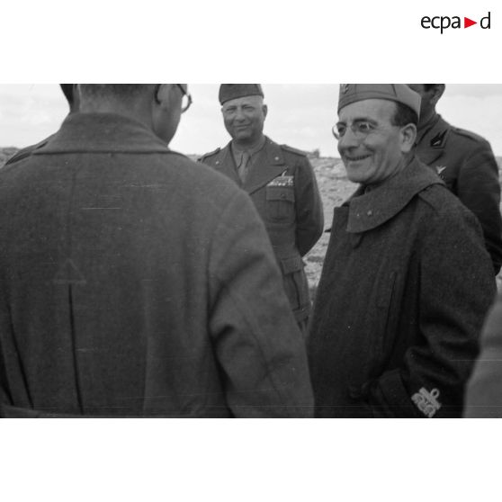 Un général de division italien est reçu par des officiers et des soldats.