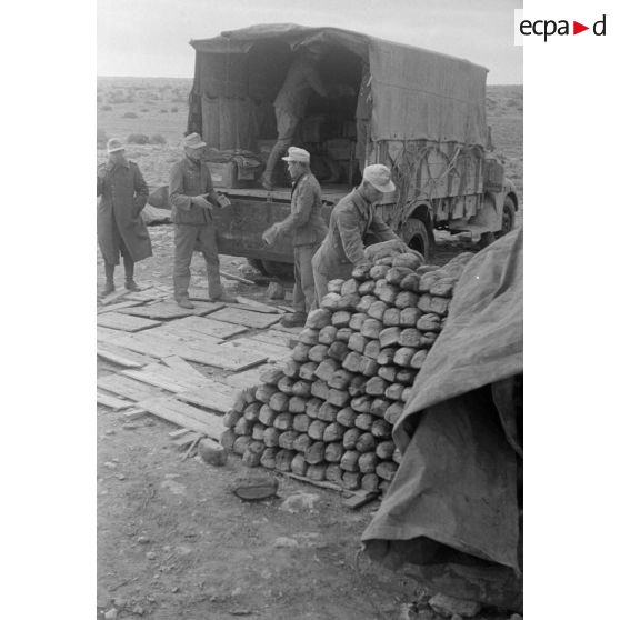 Des soldats déchargent un camion de pain.
