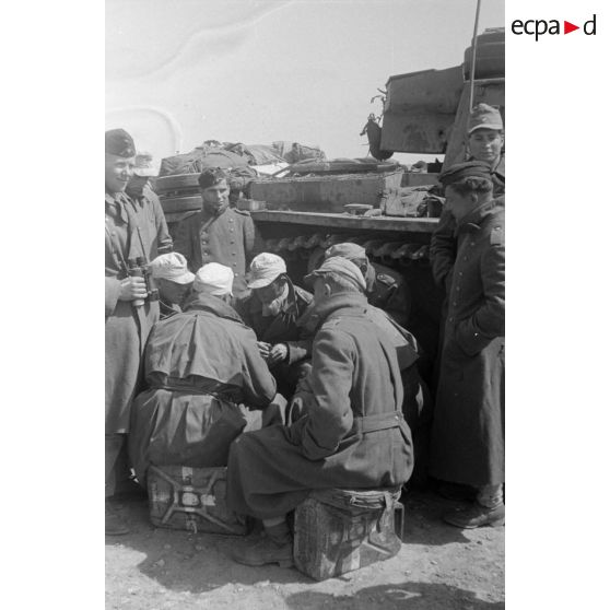 Des soldats appartenant à une unité de chars jouent aux cartes près d'un char Pz-III.