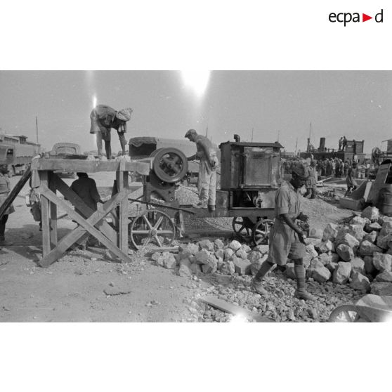 Dockers et soldats travaillant sur les quais du port de Tobrouk.