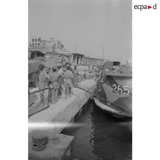 Dockers et soldats travaillant sur les quais du port de Tobrouk.