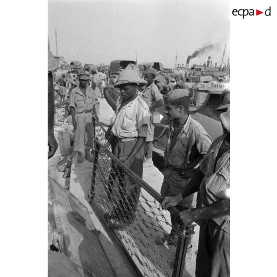Dockers et soldats travaillant sur les quais du port de Tobrouk.