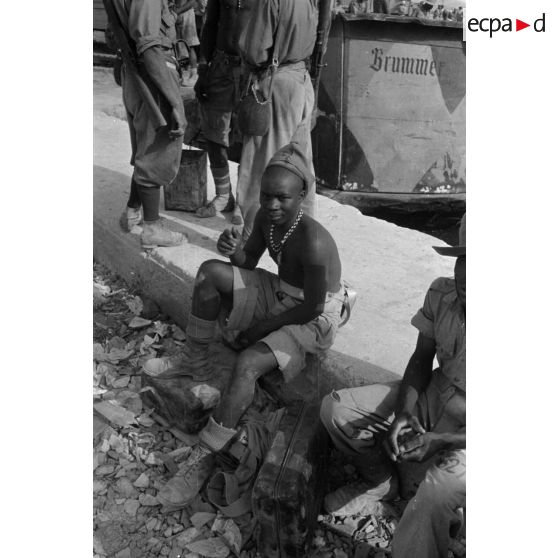 Dockers et soldats travaillant sur les quais du port de Tobrouk.